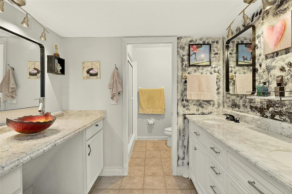 700 Starkey Road, Unit 1216 Largo, FL 33771 - Photo 16 of 32 a bathroom with a granite countertop sink a toilet and shower
