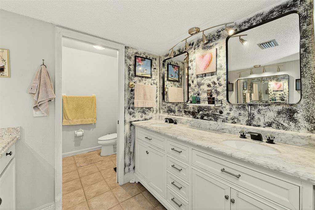 700 Starkey Road, Unit 1216 Largo, FL 33771 - Photo 18 of 32 a bathroom with a granite countertop sink mirror vanity and toilet