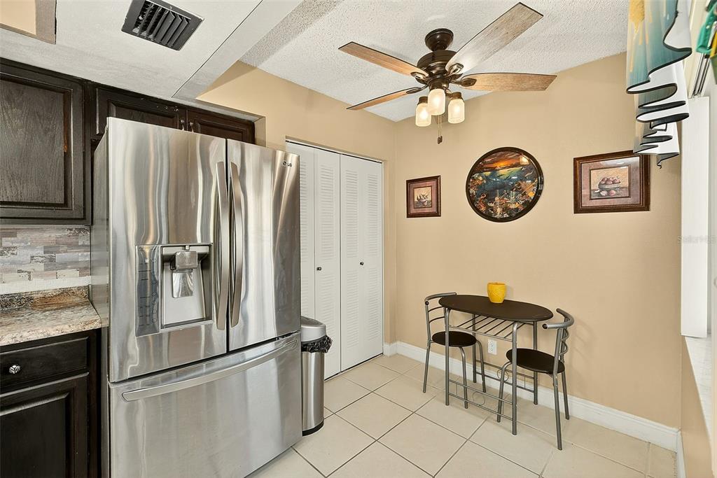 700 Starkey Road, Unit 1216 Largo, FL 33771 - Photo 9 of 32 a kitchen with a refrigerator and a table