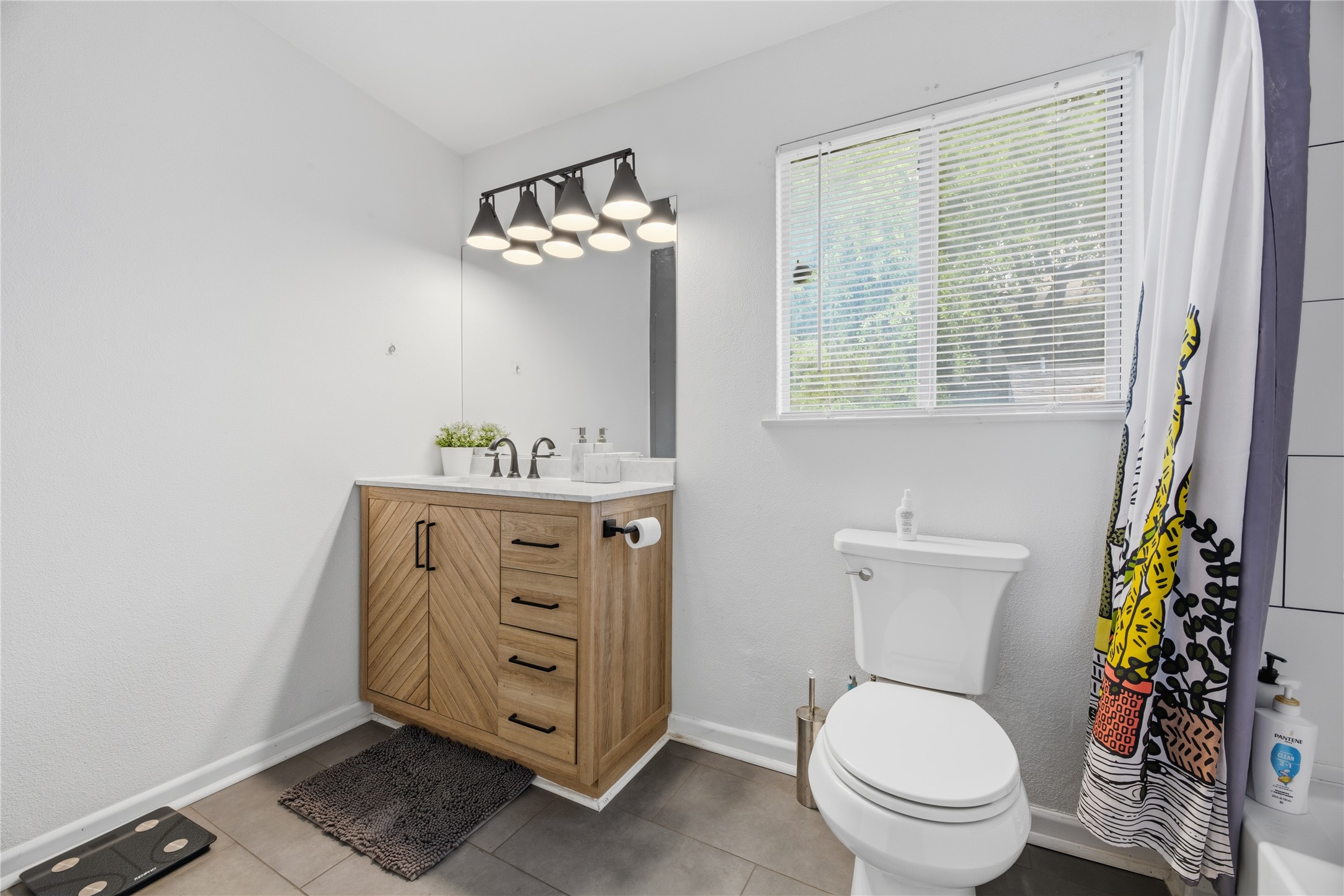 2408 Longview Street, Unit 204 Austin, TX 78705 - Photo 15 of 17 a bathroom with a granite countertop toilet a sink and a mirror