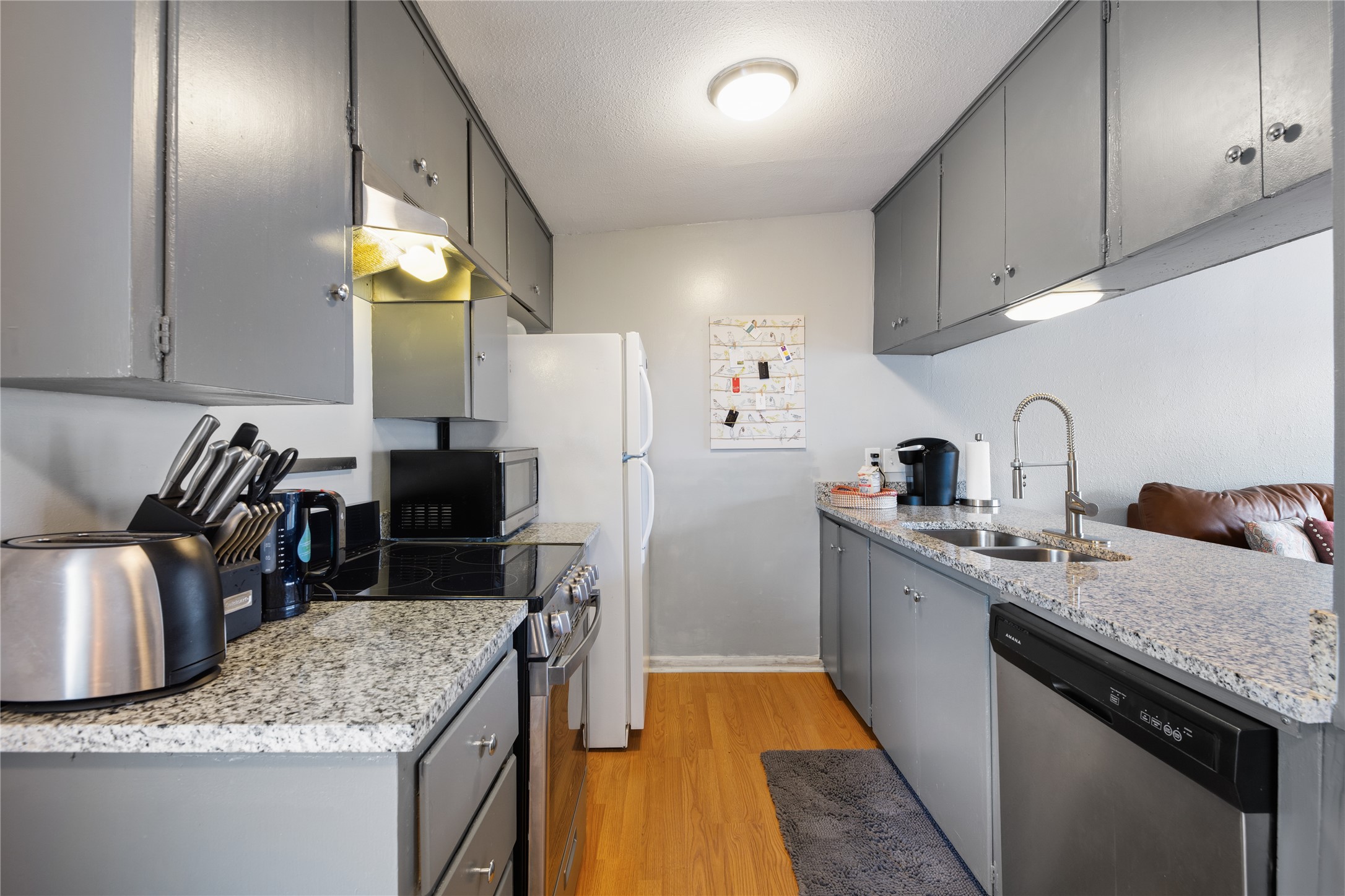 2408 Longview Street, Unit 204 Austin, TX 78705 - Photo 6 of 17 a kitchen with granite countertop a sink a stove and refrigerator