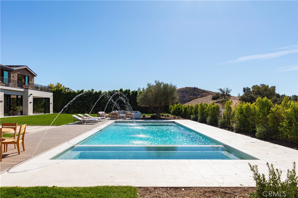 25151 Jim Bridger Road Hidden Hills, CA 91302 - Photo 27 of 32 a view of a swimming pool with a yard