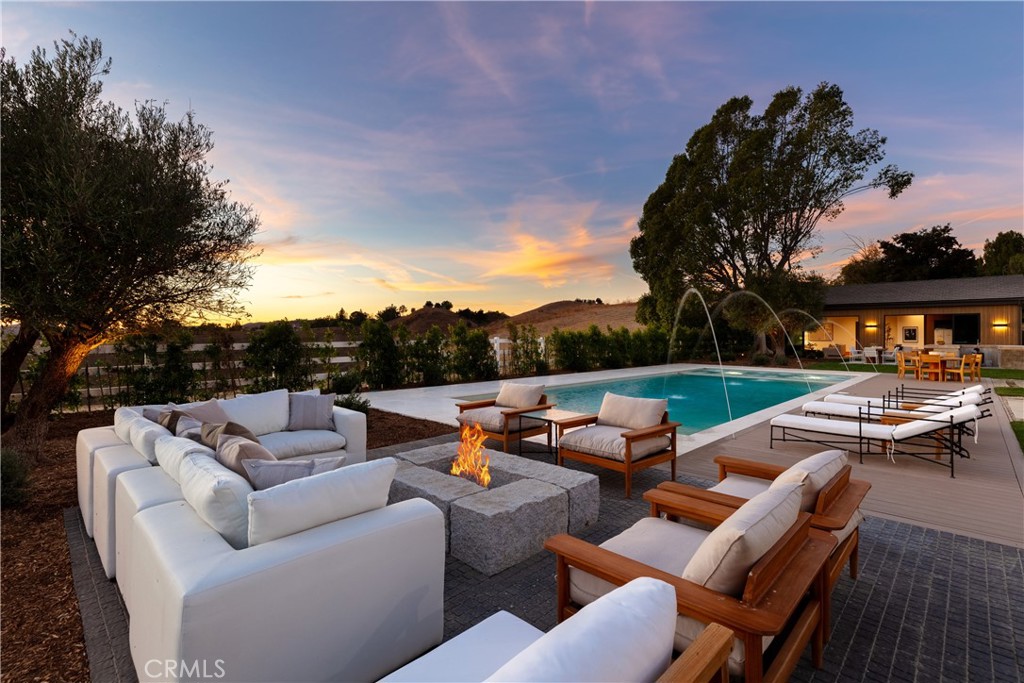 25151 Jim Bridger Road Hidden Hills, CA 91302 - Photo 31 of 32 a view of a patio with couches chairs and a fire pit