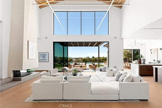 a living room with furniture a large window and a fireplace