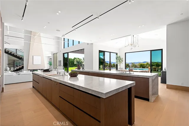 a large kitchen with kitchen island a large counter top space a sink stainless steel appliances and cabinets