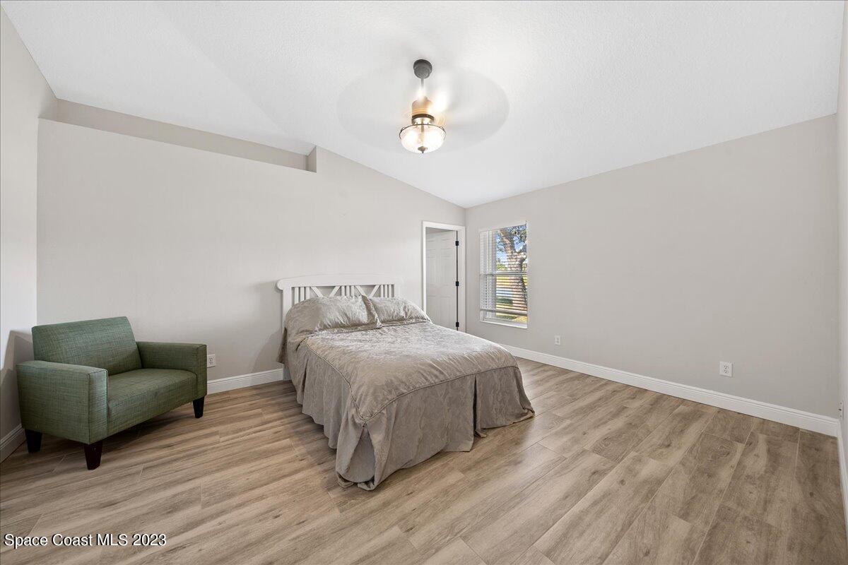 600 Benton Drive Melbourne, FL 32901 - Photo 17 of 33 a bedroom with a bed and couch with wooden floor