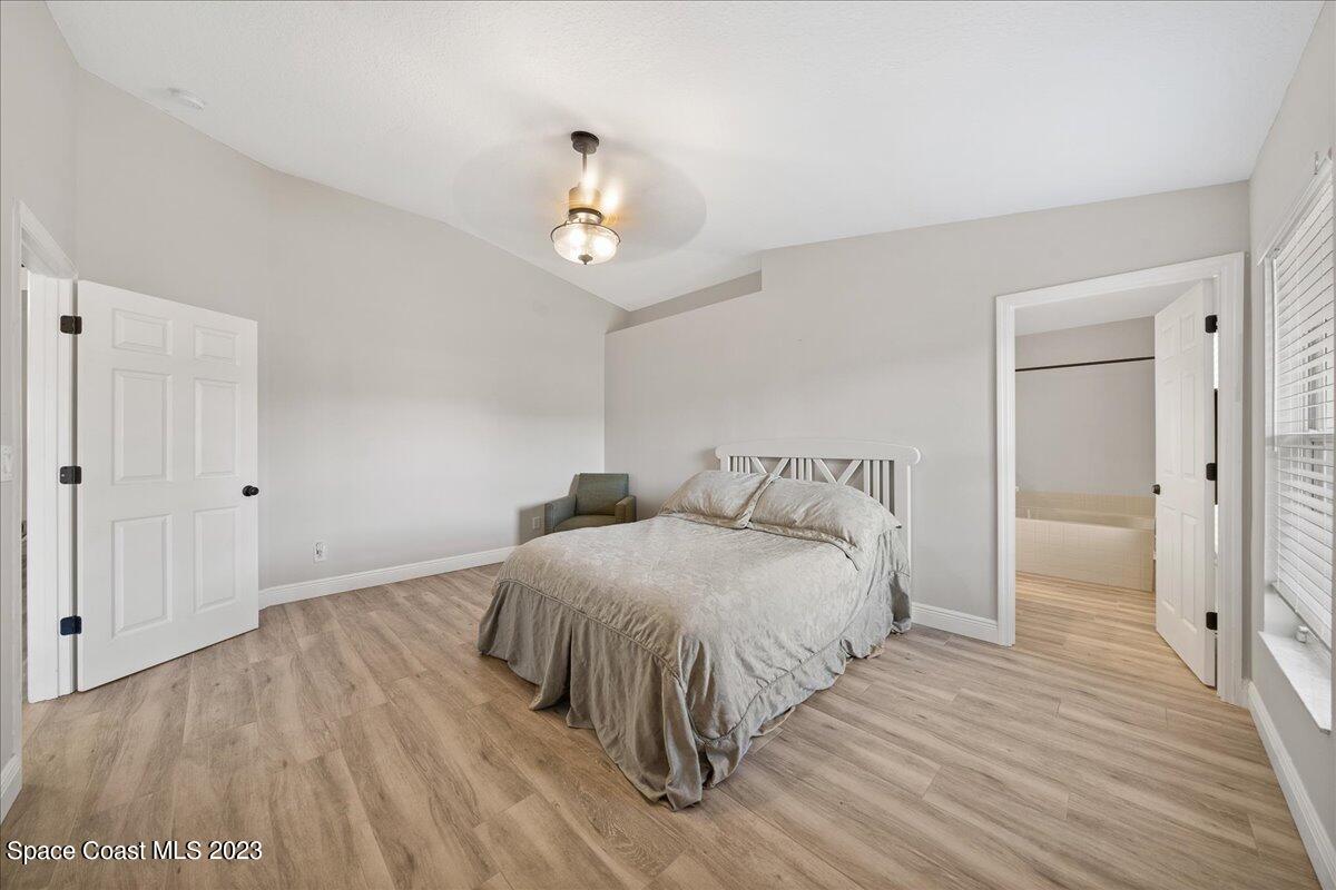 600 Benton Drive Melbourne, FL 32901 - Photo 18 of 33 a bedroom with a bed and wooden floor