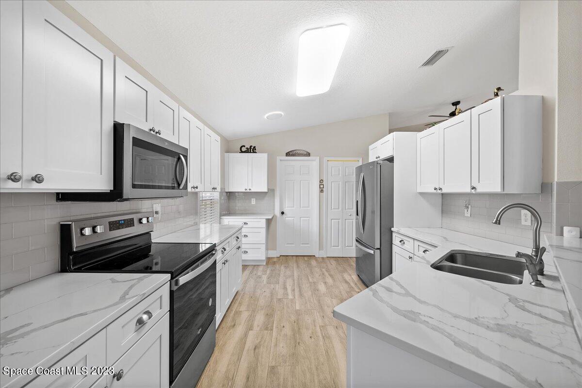 600 Benton Drive Melbourne, FL 32901 - Photo 10 of 33 a kitchen with stainless steel appliances a stove sink microwave and cabinets