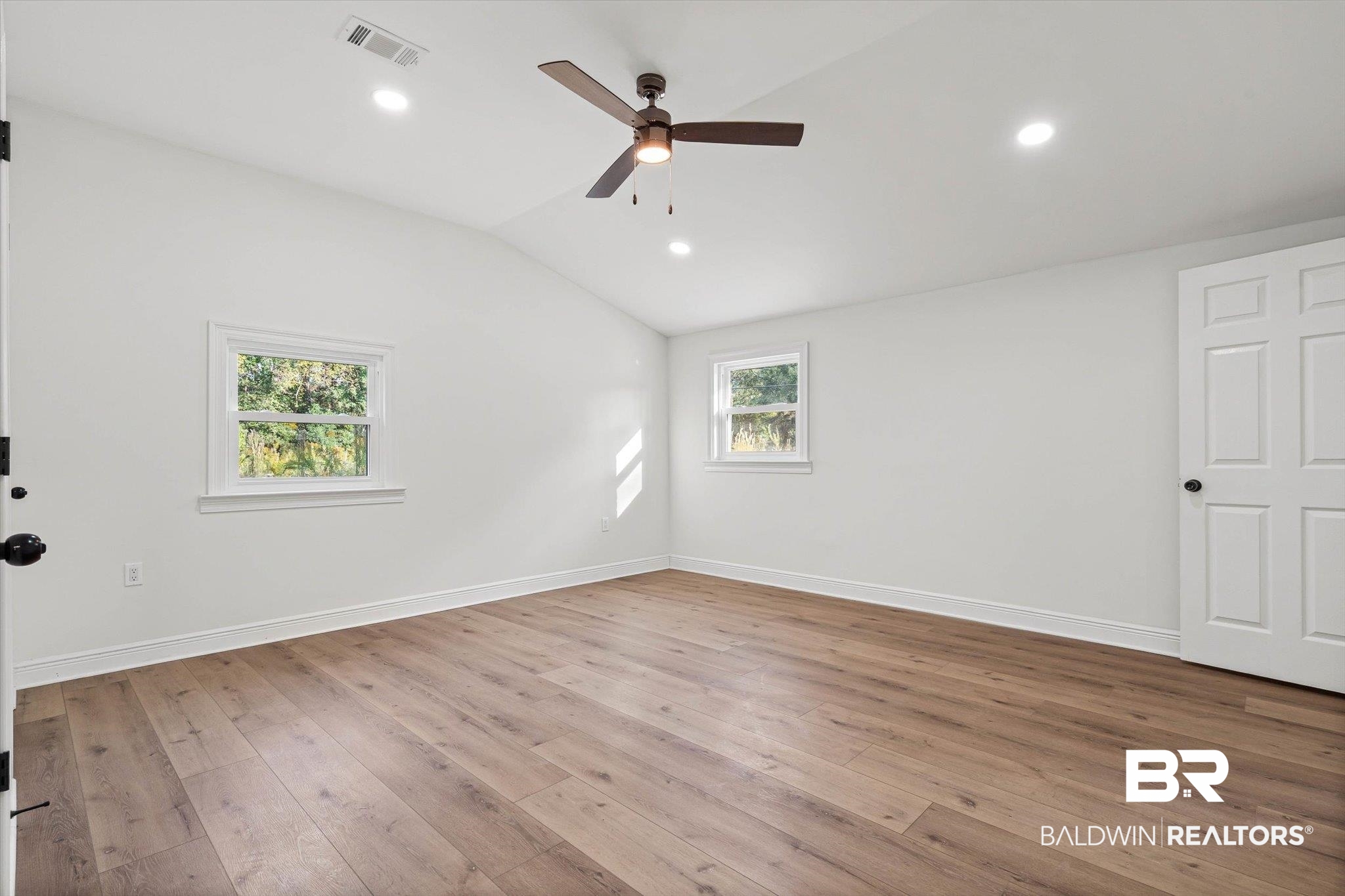 4156 Furman Drive Mobile, AL 36619 - Photo 10 of 24 Empty room with light wood-style floors, vaulted ceiling, recessed lighting, and a ceiling fan