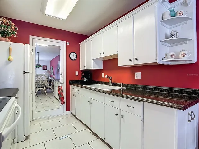 a kitchen with granite countertop a sink and cabinets