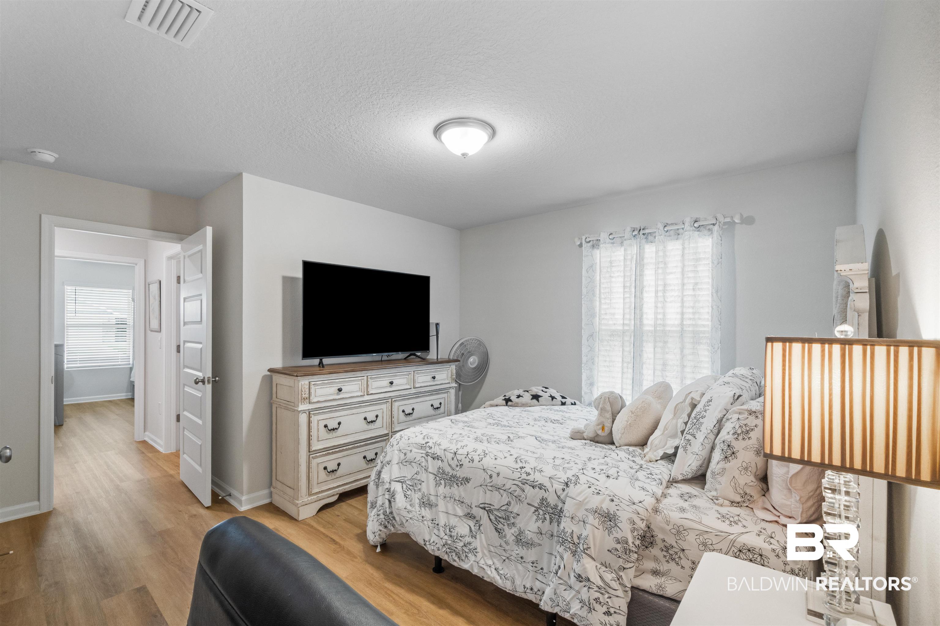 24390 Ringneck Loop Elberta, AL 36530 - Photo 27 of 39 Bedroom featuring light hardwood / wood-style floors and a textured ceiling