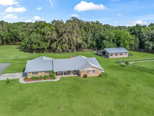 an aerial view of a house with swimming pool garden and mountain view in back