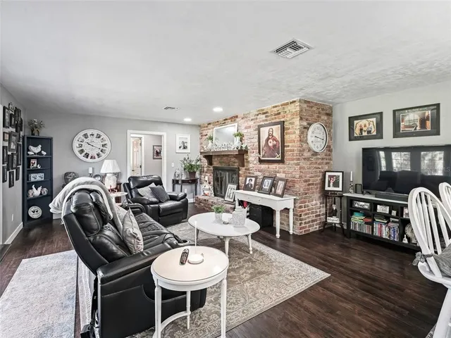 a living room with fireplace furniture and wooden floor