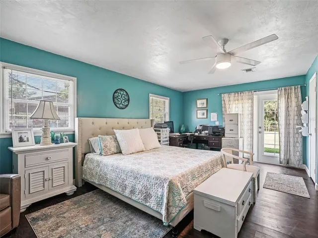 a bedroom with a large bed and wooden floor