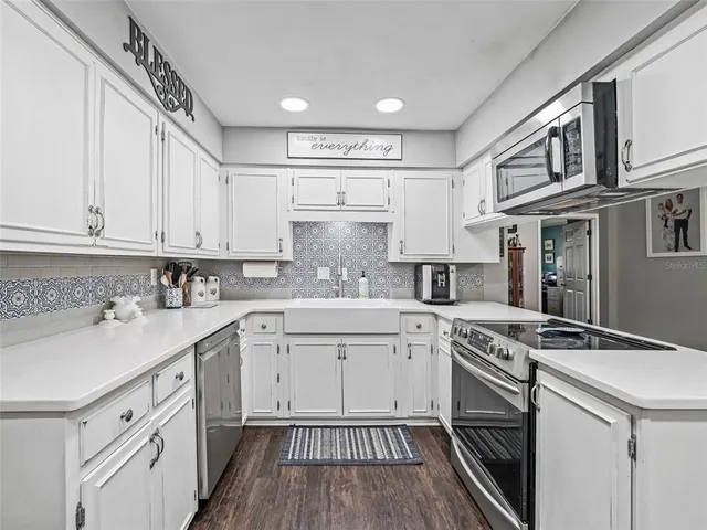 a kitchen with cabinets appliances a sink and a counter top space