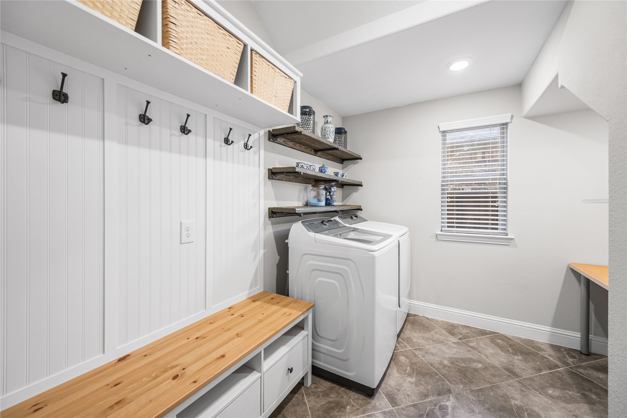 4320 Silver Oak Place Spring, TX 77386 - Photo 14 of 42 This laundry room features custom built-in shelving, ample storage, and a dedicated folding table for convenience and organization.
