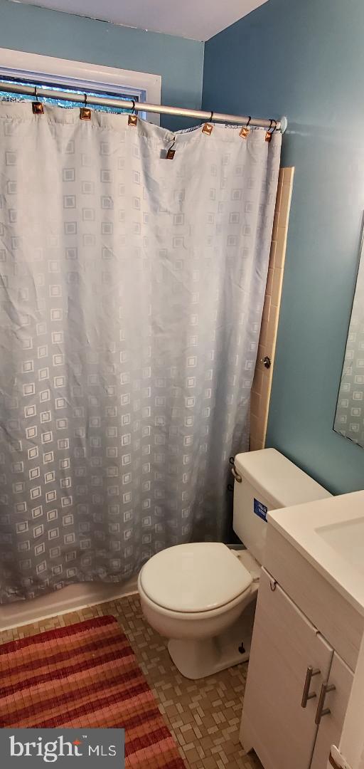 8512 Imperial Drive, Unit 1H Laurel, MD 20708 - Photo 14 of 14 a white toilet sitting next to a shower curtain