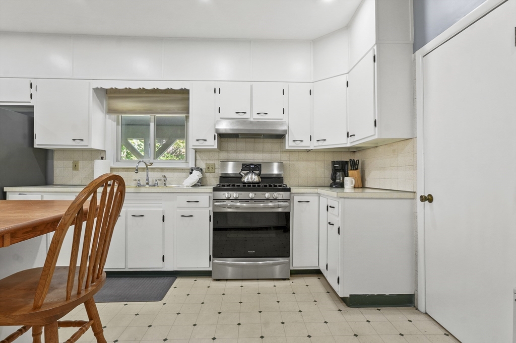 69 Eastern Avenue Woburn, MA 01801 - Photo 11 of 30 a kitchen with a stove a sink and a refrigerator