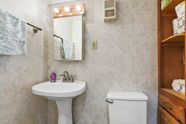 a bathroom with a toilet sink and mirror