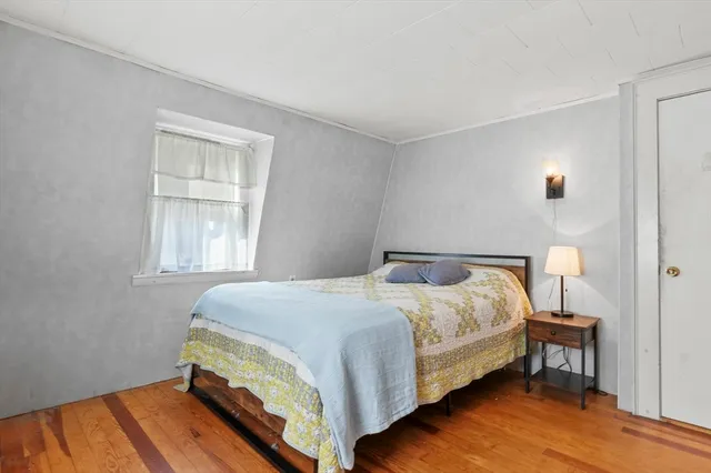 a bedroom with a bed table and a window