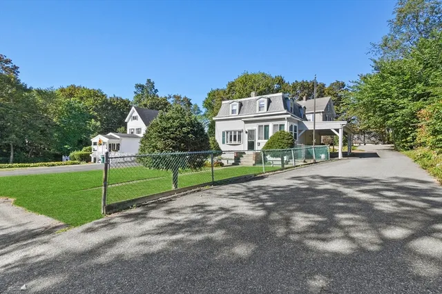 a view of a house with a big yard plants and large trees