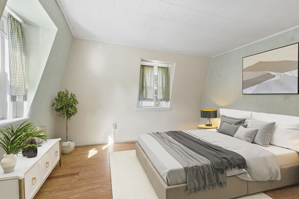69 Eastern Avenue Woburn, MA 01801 - Photo 21 of 30 a bedroom with bed and a potted plant