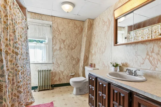 a bathroom with a sink a toilet and a mirror