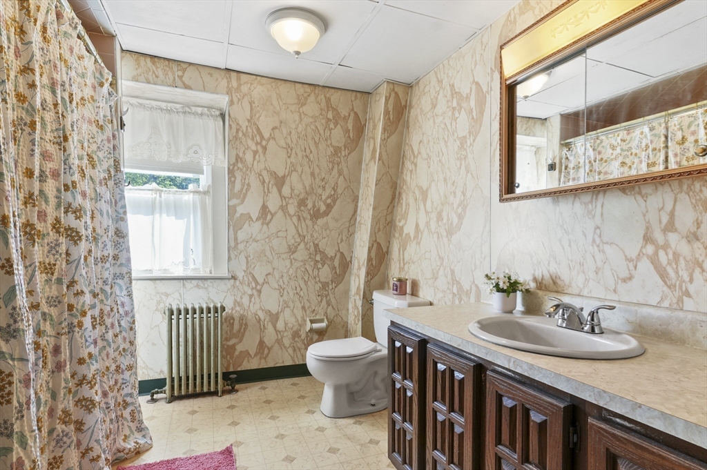 69 Eastern Avenue Woburn, MA 01801 - Photo 24 of 30 a bathroom with a sink a toilet and a mirror