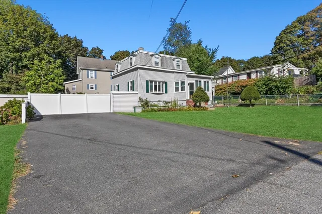 a view of a big house with a big yard and large trees