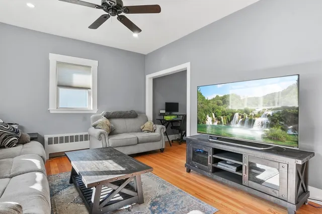 a living room with furniture a flat screen tv and a large window