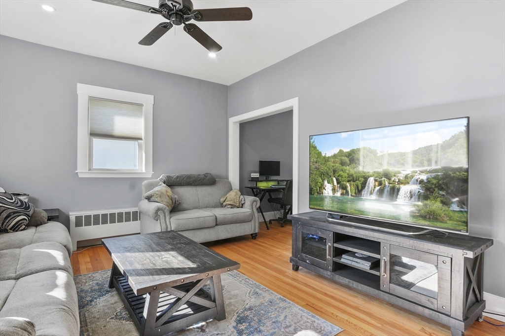 69 Eastern Avenue Woburn, MA 01801 - Photo 5 of 30 a living room with furniture a flat screen tv and a large window