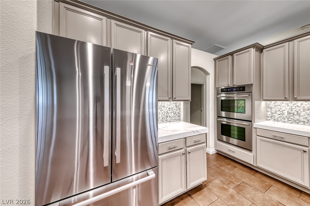 2122 Mooreview Street Henderson, NV 89012 - Photo 12 of 44 Culinary delights await in this chef's kitchen featuring double ovens and sleek stainless steel appliances.