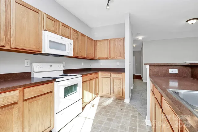 a view of an empty room with window and chandelier fan