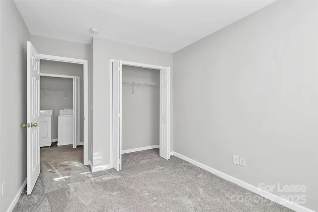 a view of an empty room with a chandelier fan