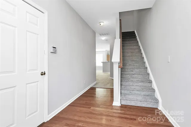 a view of a hallway with wooden floor and staircase