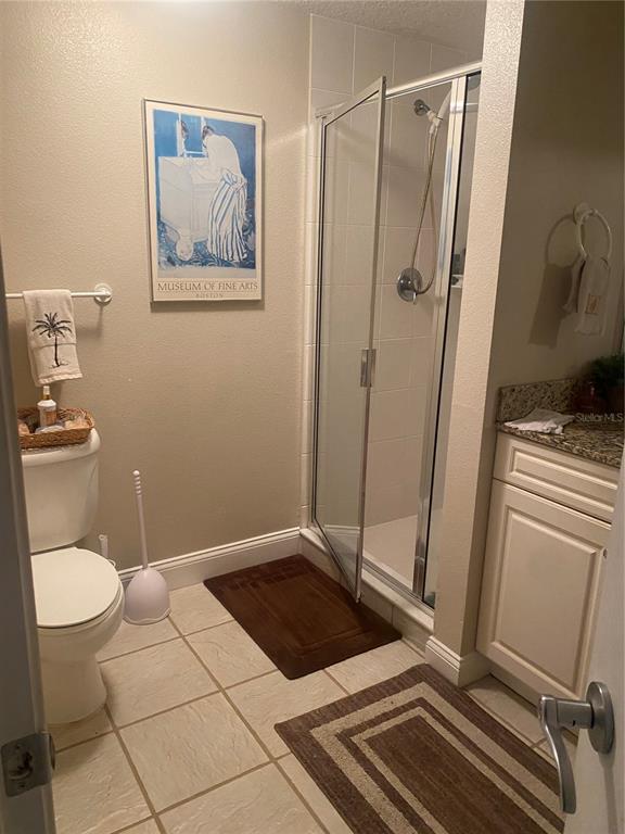 60 Surfview Drive, Unit 121 Palm Coast, FL 32137 - Photo 10 of 13 a bathroom with a granite countertop sink toilet and shower
