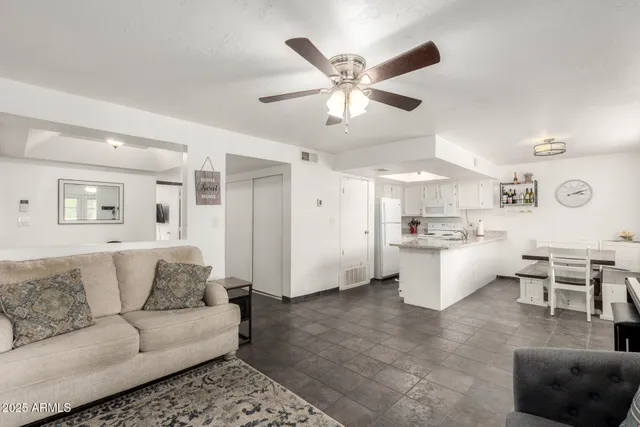 a living room with furniture and view of kitchen