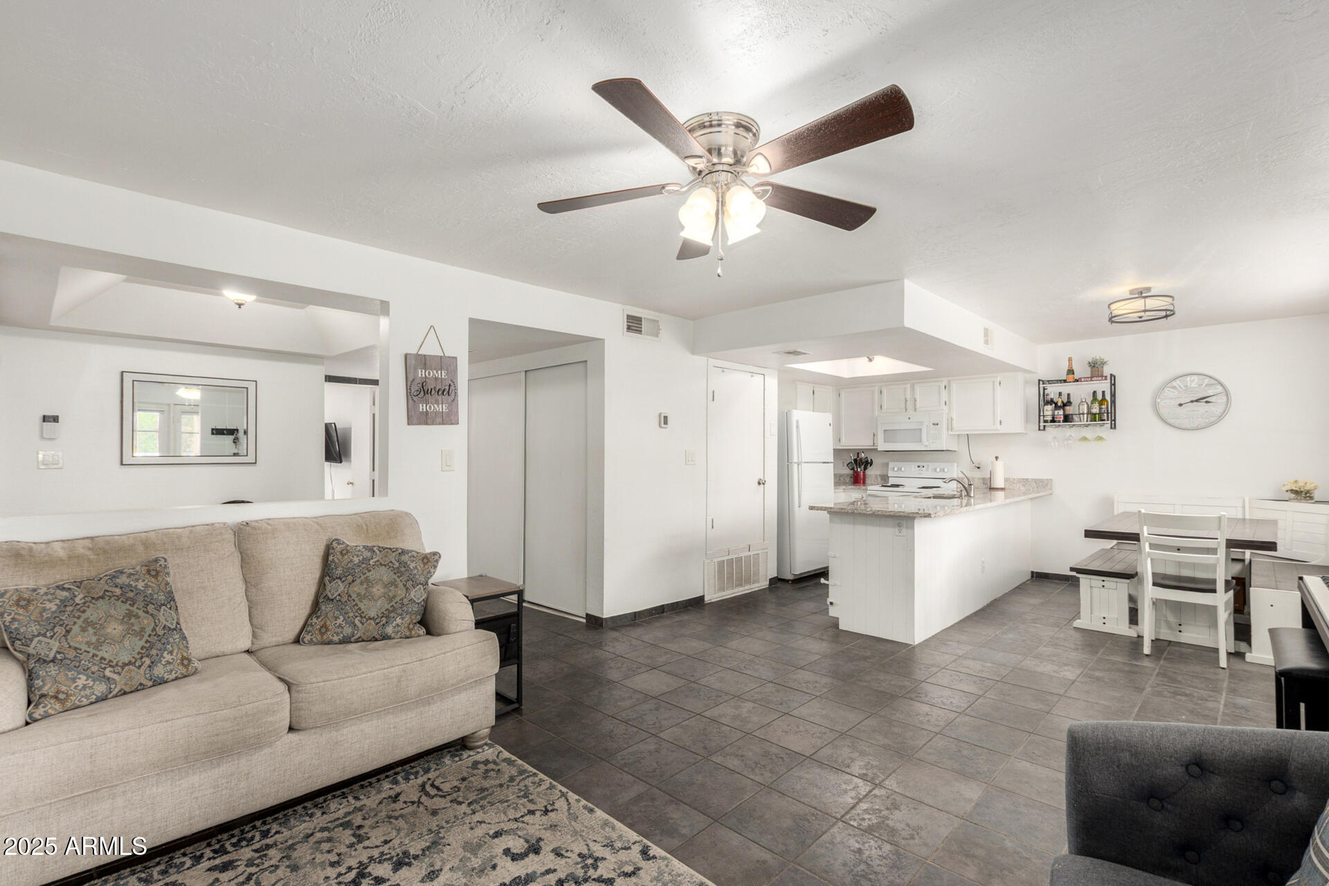 a living room with furniture and view of kitchen