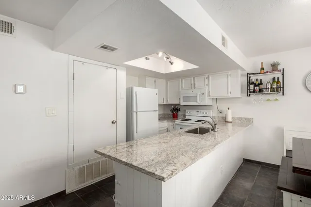 a kitchen with kitchen island a sink appliances and cabinets