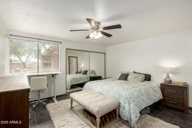 a bedroom with a bed and a large window with wooden floor