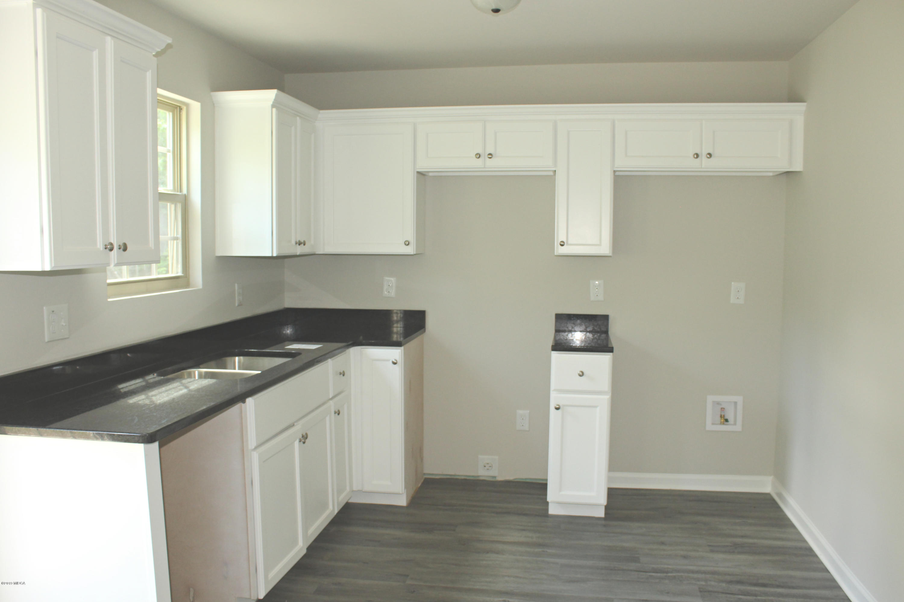 757 Weldon Road Forsyth, GA 31029 - Photo 4 of 8 a kitchen with granite countertop a sink and a stove
