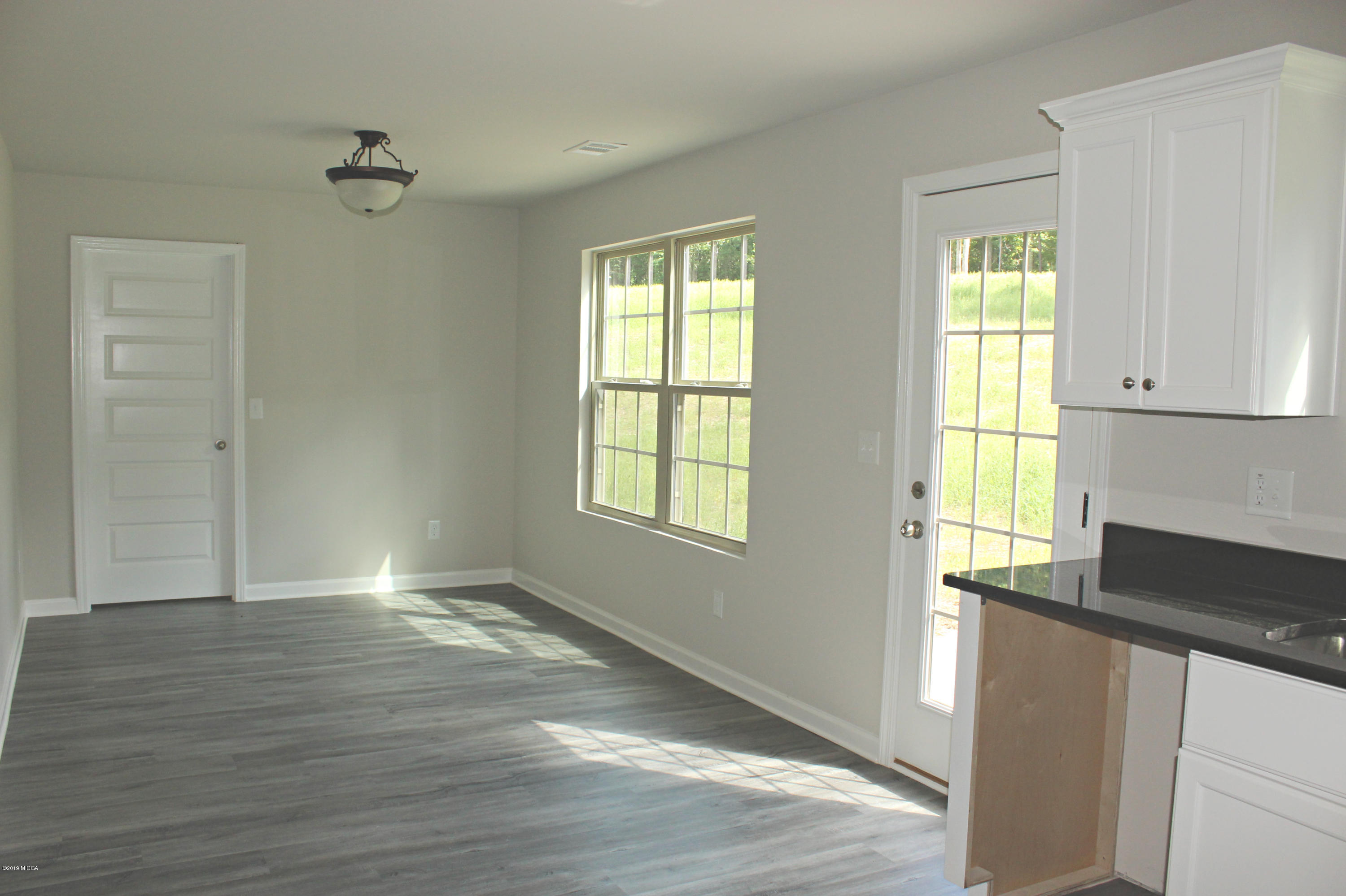 757 Weldon Road Forsyth, GA 31029 - Photo 5 of 8 a view of an empty room with wooden floor and a window