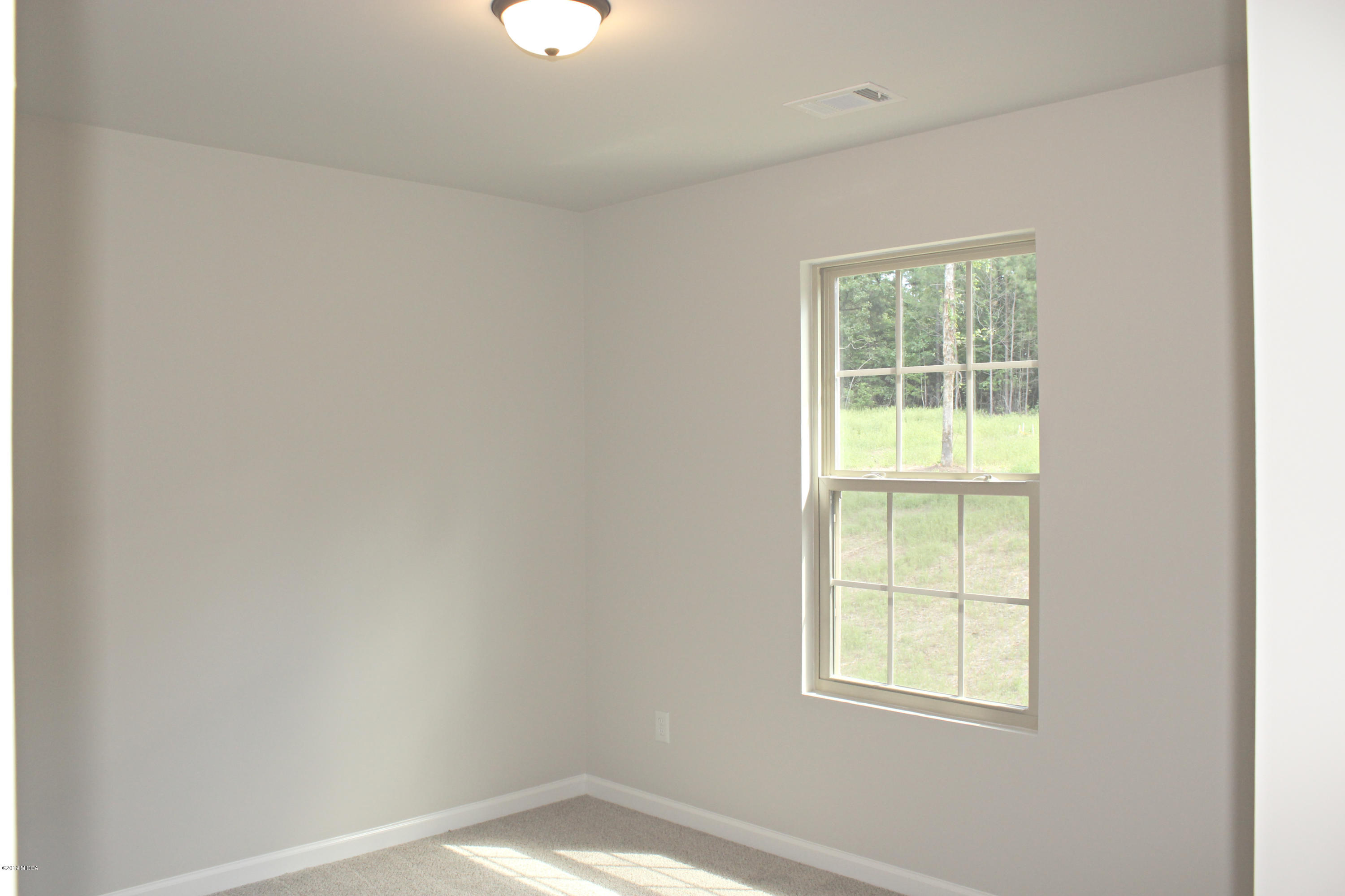 757 Weldon Road Forsyth, GA 31029 - Photo 8 of 8 an empty room with a window