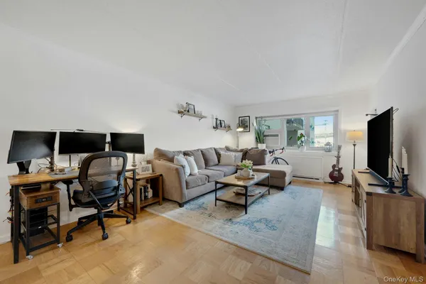 a living room with furniture a flat screen tv and a window