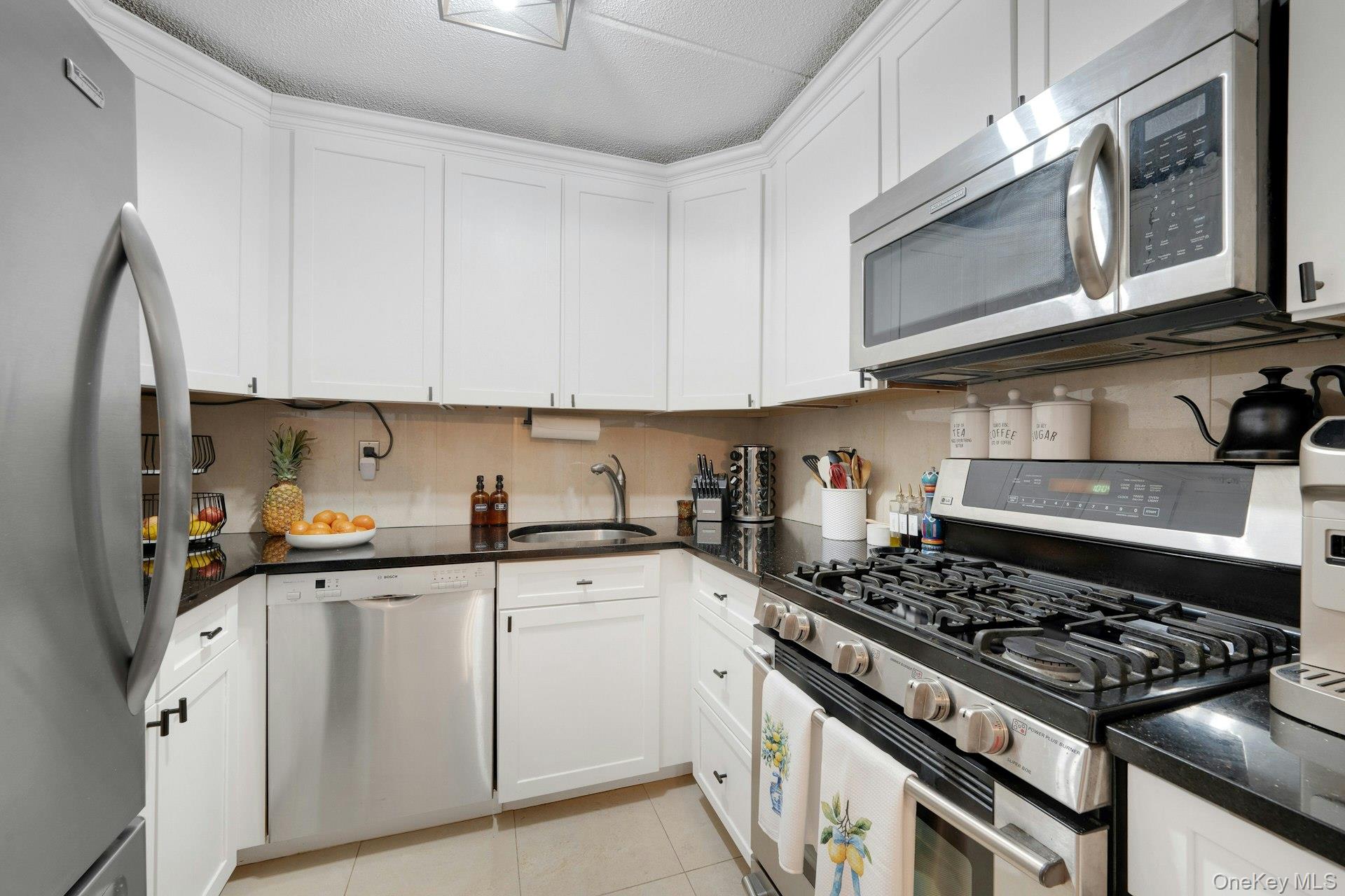 480 Halstead Avenue, Unit 2J Harrison, NY 10528 - Photo 9 of 16 a kitchen with stainless steel appliances granite countertop a stove a sink dishwasher and cabinets with wooden floor