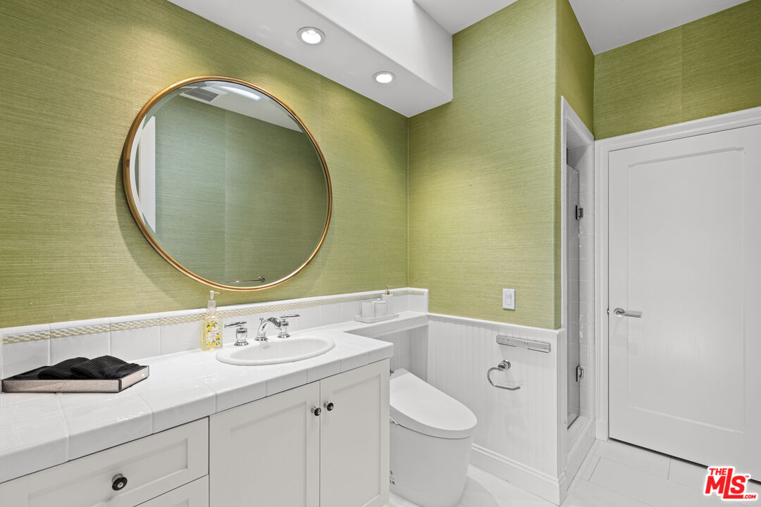 2305 Canyonback Road Los Angeles, CA 90049 - Photo 19 of 26 a bathroom with a granite countertop toilet sink and mirror
