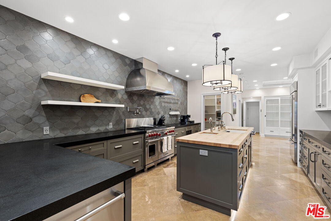 2305 Canyonback Road Los Angeles, CA 90049 - Photo 8 of 26 a kitchen with stainless steel appliances granite countertop a sink a stove and a refrigerator