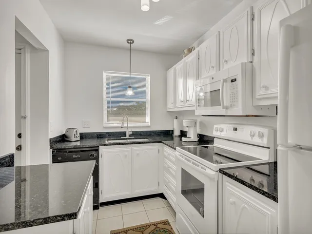a kitchen with white cabinets and appliances