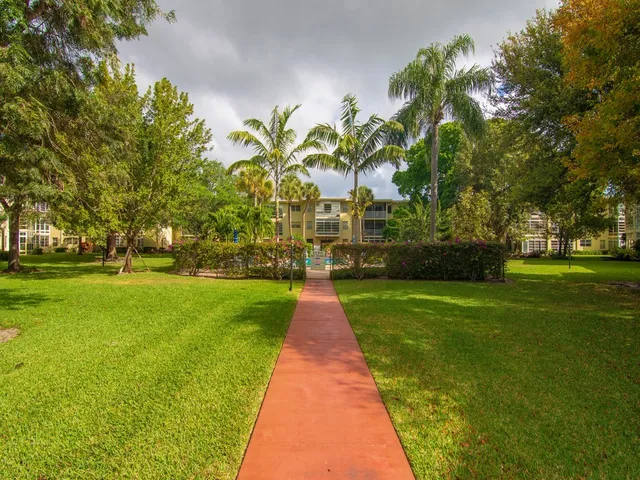 a view of a big building with a big yard and large trees
