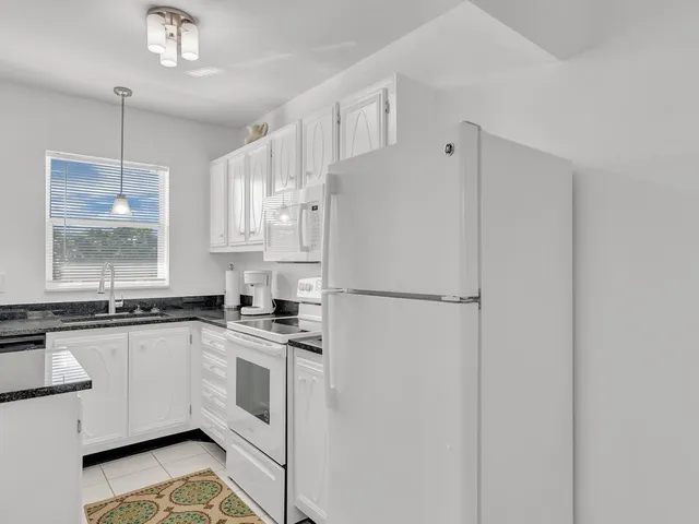 a kitchen with white cabinets and white appliances